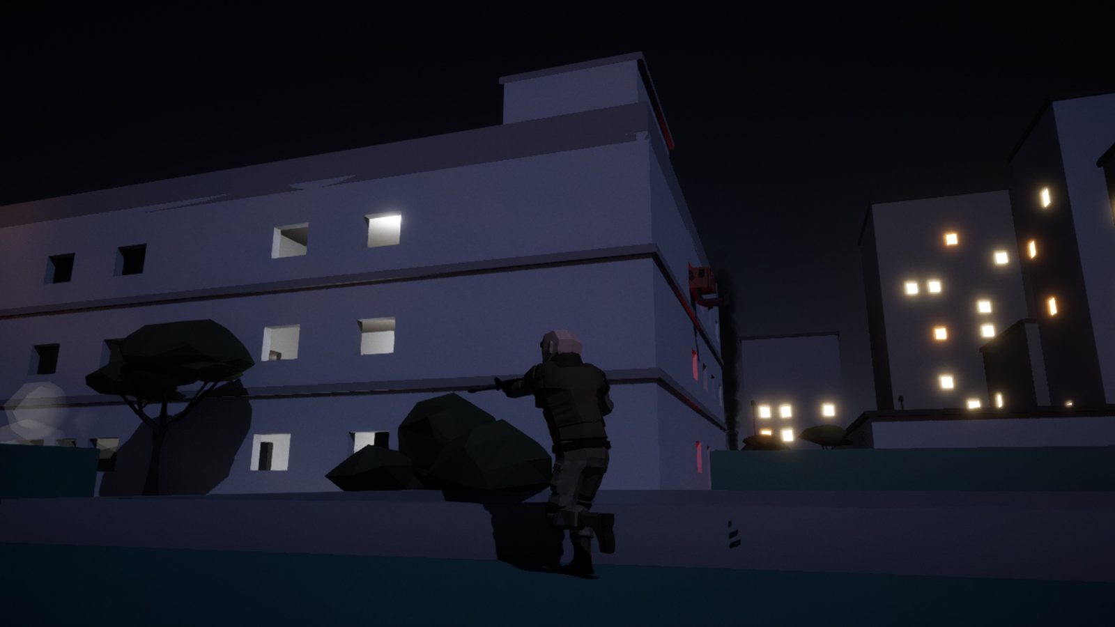 Embassy compound at night with the lit city skyline behind
